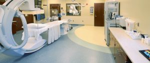 Multi-toned seamless commercial sheet flooring with custom curved inlays installed in a medical surgery room by All Floors Commercial.